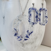 Load image into Gallery viewer, Handmade real flower oval pendant necklace accompanied by a pair of oval stud earrings made with blue cornflower and silver flakes preserved in resin. Necklace Set - Resin Flower Jewelry - Flower Jewelry