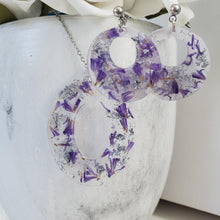 Load image into Gallery viewer, Handmade real flower resin oval necklace accompanied by a pair of round earrings made with purple statice and silver flakes. - Flower Jewelry, Bridal Gifts, Jewelry Set