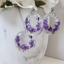 Load image into Gallery viewer, Handmade real flower circular pendant necklace accompanied by a matching pair of stud earrings made with purple statice and silver leaf preserved in resin. - Resin Jewelry, Bridal Sets, Jewelry Sets