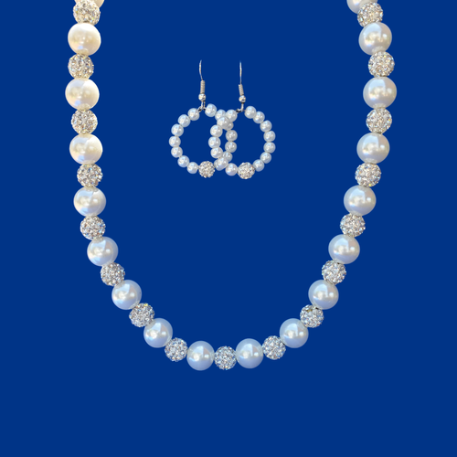 A handmade pearl and crystal necklace accompanied by a pair of hoop earrings.