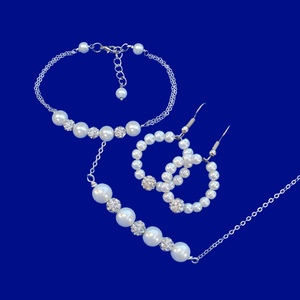 A handmade pearl and crystal bar necklace accompanied by a matching bracelet and a pair of hoop earrings.