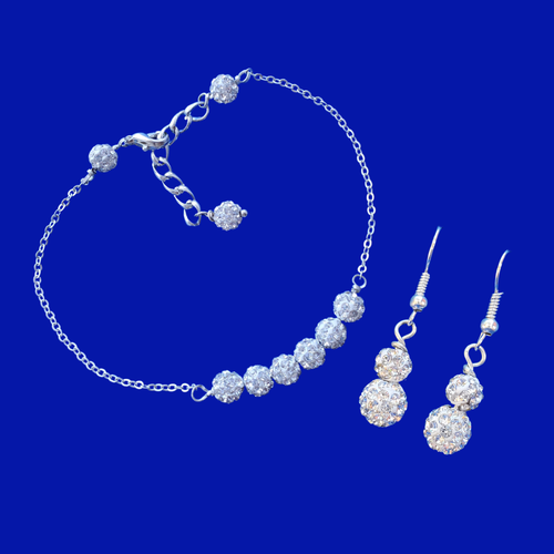 A handmade dainty crystal bar bracelet accompanied by a pair of drop earrings.