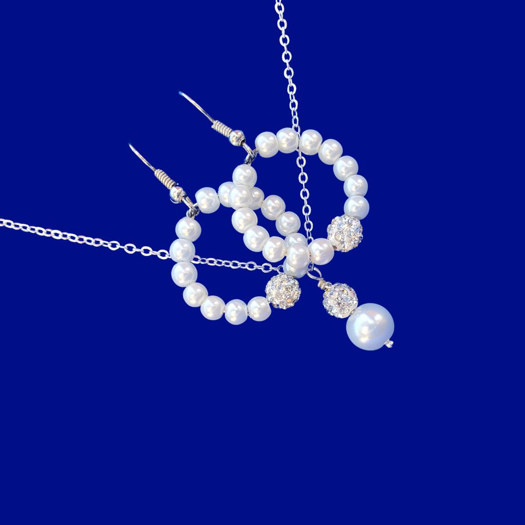 A pearl and crystal drop necklace accompanied by a pair of hoop earrings.