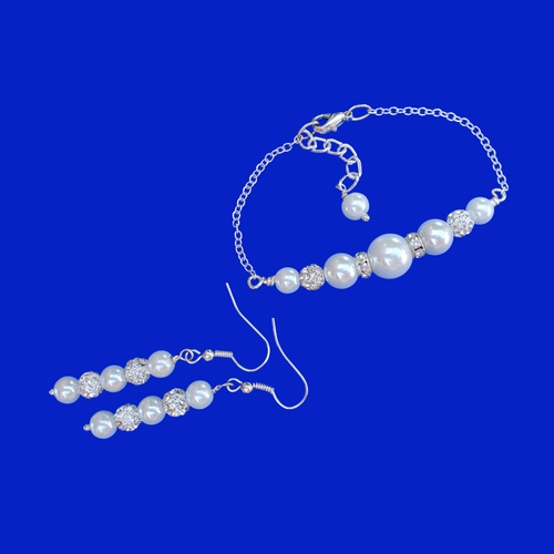 A pearl and crystal bar bracelet accompanied by a pair of drop earrings.