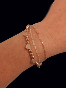A beautiful rose gold bracelet constructed with one strand of natural hematite beads combined with rose gold plated hearts. One strand of rose gold plated chain coupled with one strand of .925 sterling silver chain. 