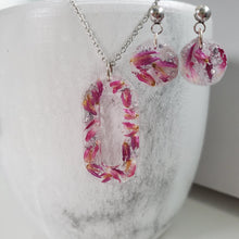 Load image into Gallery viewer, Handmade real flower oval pendant necklace accompanied by a pair of circular stud earrings made with red clover flowers and silver flakes. Jewelry Sets, Flower Jewelry, Necklace Set