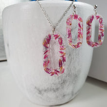 Load image into Gallery viewer, Handmade real flower oval pendant necklace accompanied by a matching pair of dangling stud earrings made with red clover flowers and silver flakes preserved in resin. - Jewelry Sets, Resin Flower Jewelry, Necklace Set