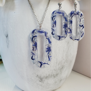 Handmade real flower oval pendant necklace accompanied by a matching pair of dangling stud earrings made with blue cornflower and silver flakes preserved in resin. - Jewelry Sets, Resin Flower Jewelry, Necklace Set