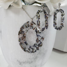 Load image into Gallery viewer, Handmade real flower oval pendant necklace accompanied by a pair of stud dangling earrings made with lavender petals and silver flakes preserved in resin. Resin Flower Jewelry - Necklace And Earring Set