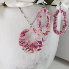 Load image into Gallery viewer, Handmade real flower circular pendant necklace accompanied by a pair of oval stud drop earrings made with red clover flowers and silver flakes preserved in resin. Resin Flower Jewelry, Bridal Sets, Jewelry Sets