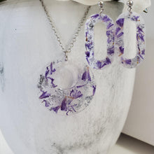 Load image into Gallery viewer, Handmade real flower circular pendant necklace accompanied by a pair of oval stud drop earrings made with statice and silver flakes preserved in resin. Resin Flower Jewelry, Bridal Sets, Jewelry Sets