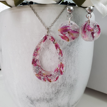 Load image into Gallery viewer, Handmade real flower teardrop pendant necklace accompanied by a pair of circular stud earrings made with red clover flowers and silver flakes preserved in resin. Jewelry Sets, Flower Jewelry, Resin Jewelry