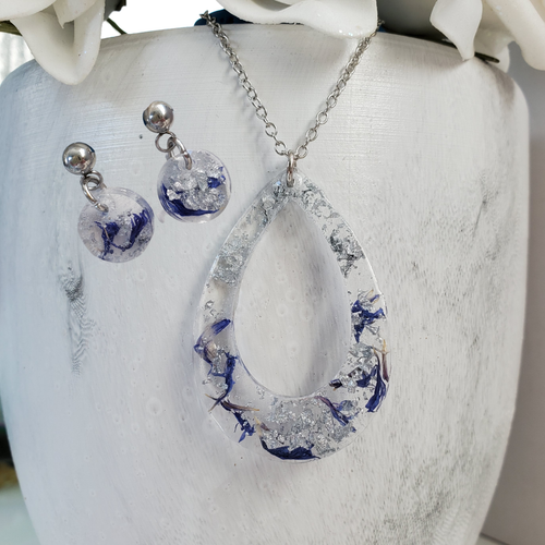 Handmade real flower teardrop pendant necklace accompanied by a pair of circular stud earrings made with blue cornflower and silver flakes preserved in resin. Jewelry Sets, Flower Jewelry, Resin Jewelry