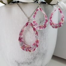 Load image into Gallery viewer, Handmade real flower teardrop pendant necklace accompanied by a matching pair of stud drop earrings made with red clover flowers and silver flakes preserved in resin. Resin Jewelry, Flower Jewelry, Jewelry Sets