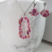 Load image into Gallery viewer, Handmade real flower oval pendant necklace accompanied by a matching pair of dangling stud earrings made with red clover flowers and silver flakes preserved in resin. - Red Jewelry, Jewelry Sets, Flower Jewelry