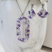 Load image into Gallery viewer, Handmade real flower oval pendant necklace accompanied by a matching pair of dangling stud earrings made with purple statice and silver flakes preserved in resin. - Red Jewelry, Jewelry Sets, Flower Jewelry