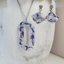Load image into Gallery viewer, Handmade real flower oval pendant necklace accompanied by a matching pair of dangling stud earrings made with blue cornflower and silver flakes preserved in resin. - Red Jewelry, Jewelry Sets, Flower Jewelry