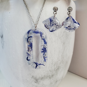Handmade real flower oval pendant necklace accompanied by a matching pair of dangling stud earrings made with blue cornflower and silver flakes preserved in resin. - Red Jewelry, Jewelry Sets, Flower Jewelry